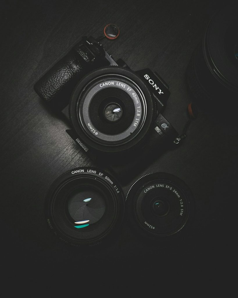 Professional camera bodies and lenses arranged on a dark studio surface