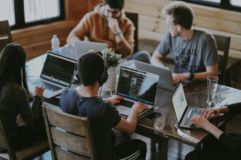 Team collaborating on laptops in a studio workspace